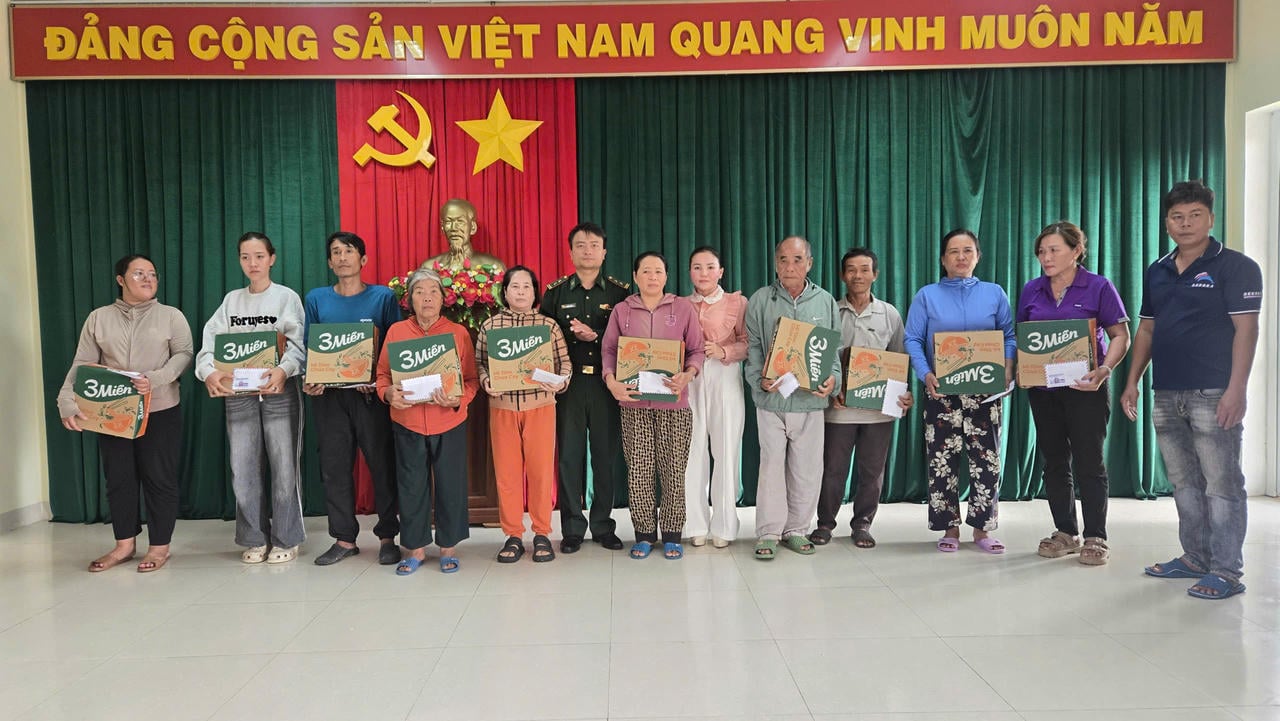 Reportér novin PLVN dává dárky obyvatelům obce Nhon Ly.