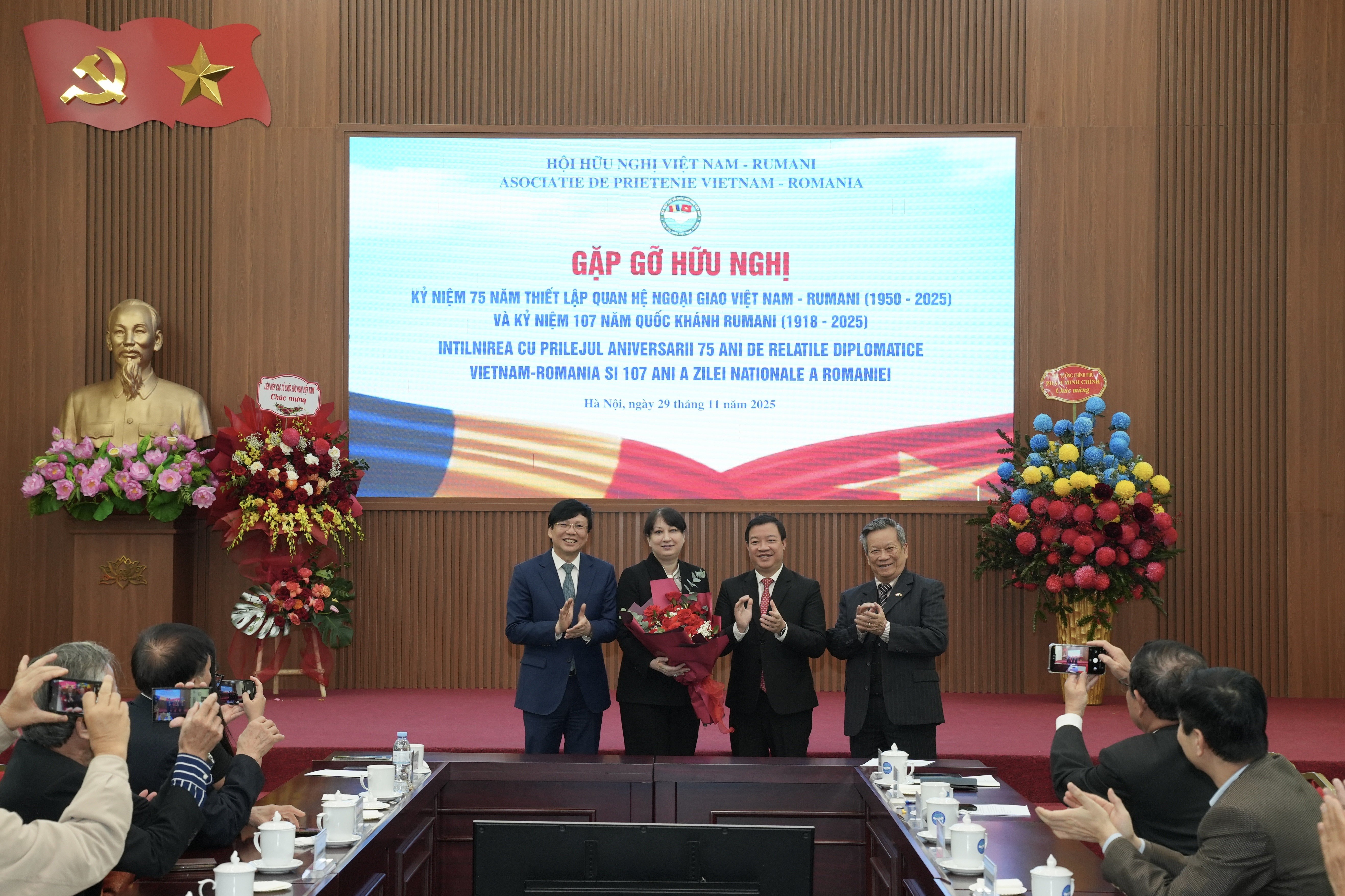 Phó chủ tịch Liên hiệp các tổ chức hữu nghị Việt Nam Nguyễn Ngọc Hùng (thứ hai, từ phải sang) tặng hoa chúc mừng Quốc khánh Romania.