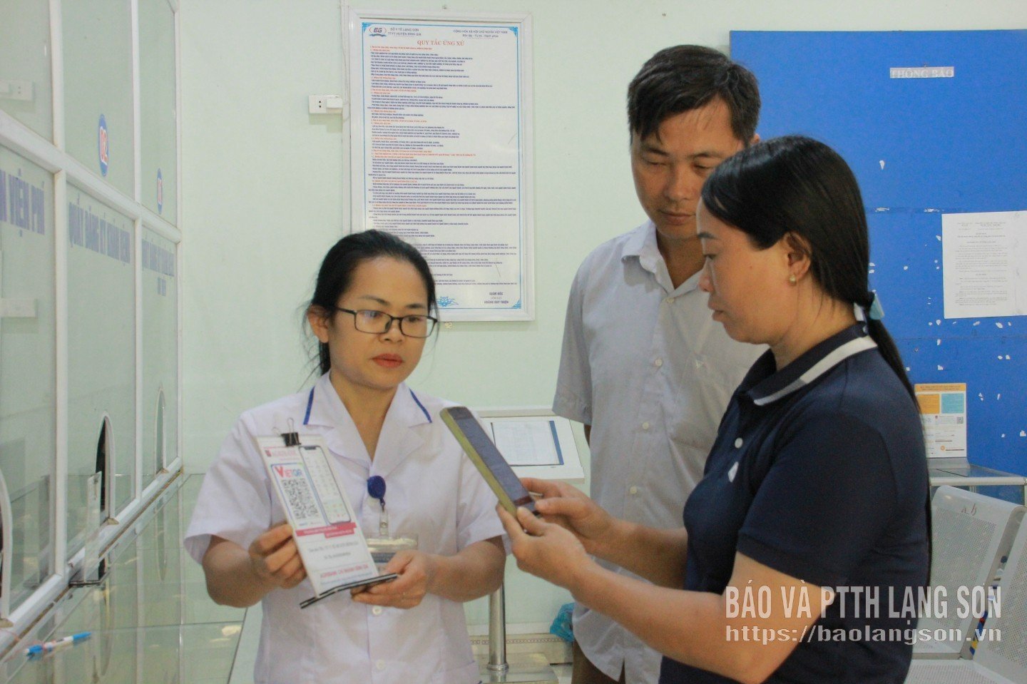 Співробітники Регіонального медичного центру Бінь Зя навчають людей сканувати QR-коди для безготівкових платежів.