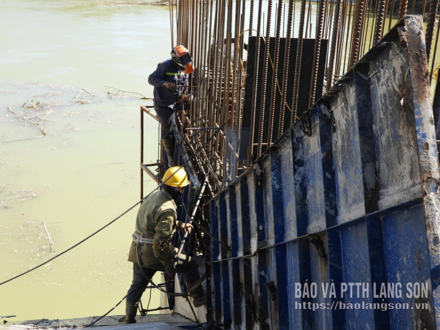 A Trung Van Development Construction Company Limited munkásai acélszerkezetet szerelnek és betont öntenek a gyár túlfolyó falába.