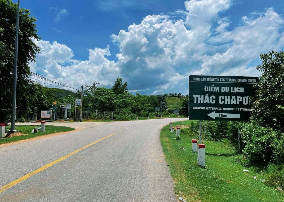 Bảng chỉ dẫn bằng gỗ ghi chữ 'Thác Chapơr' đặt bên con đường đất dẫn vào khu vực thác.