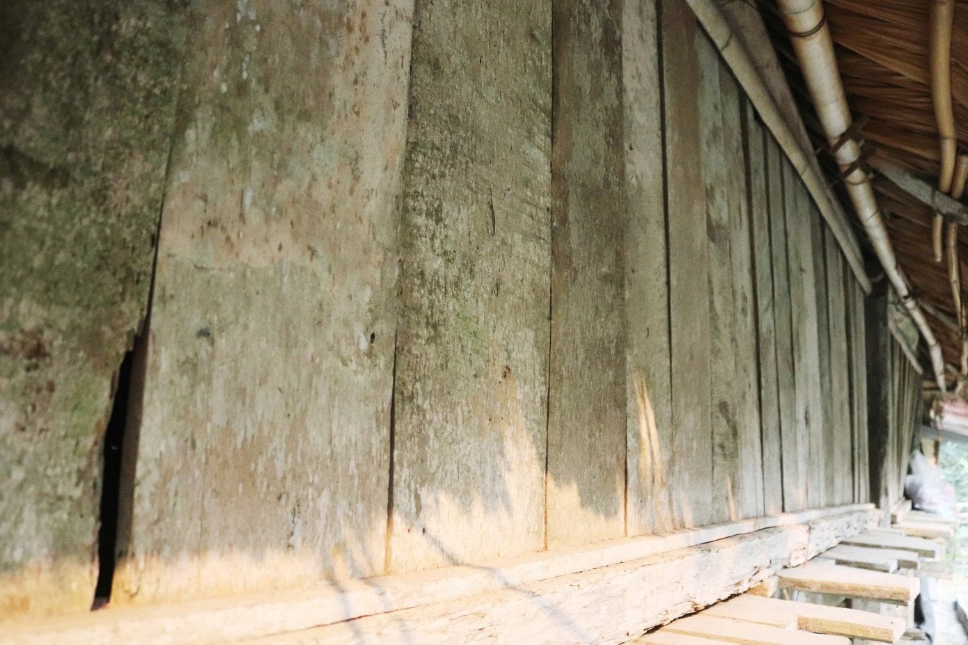 Närbild av ett hus på pålar helt av trä, som demonstrerar Muong-folkets unika byggteknik.