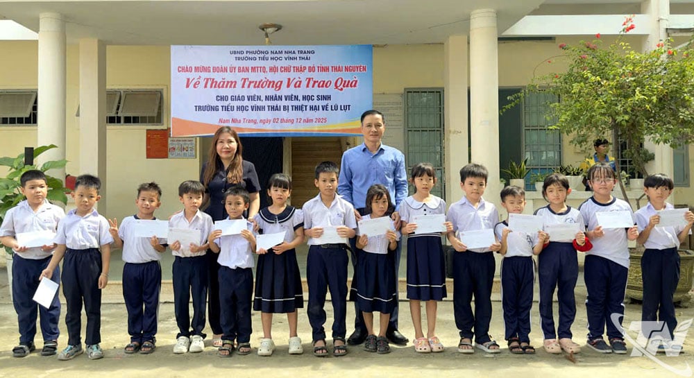 O camarada Vu Duy Hoang entrega presentes aos alunos da Escola Primária Vinh Thai.