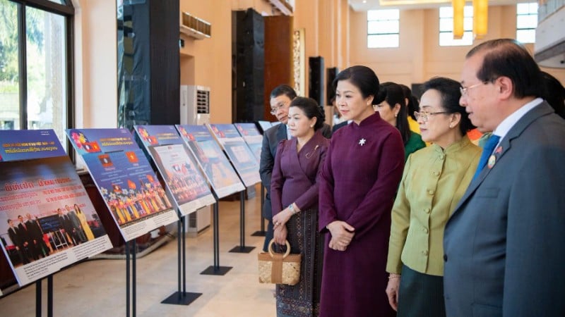 Phu nhân Ngô Phương Ly và Phu nhân Naly Sisoulith cùng các khách mời tham quan khu vực Triển lãm ảnh quan hệ Việt Nam-Lào. (Ảnh: Nguyễn Hồng)