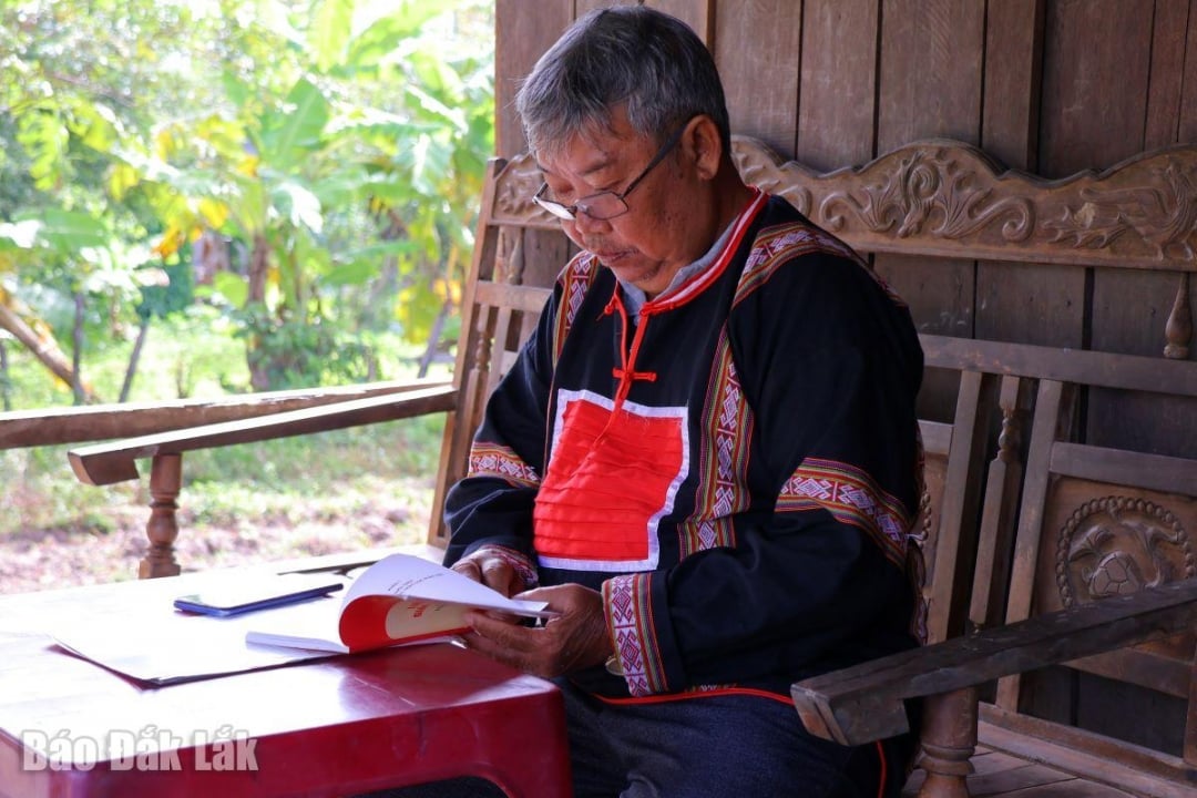 وای تونگ کدوه، بزرگ روستا، برای تبلیغات، اسناد قانونی را مطالعه می‌کند.