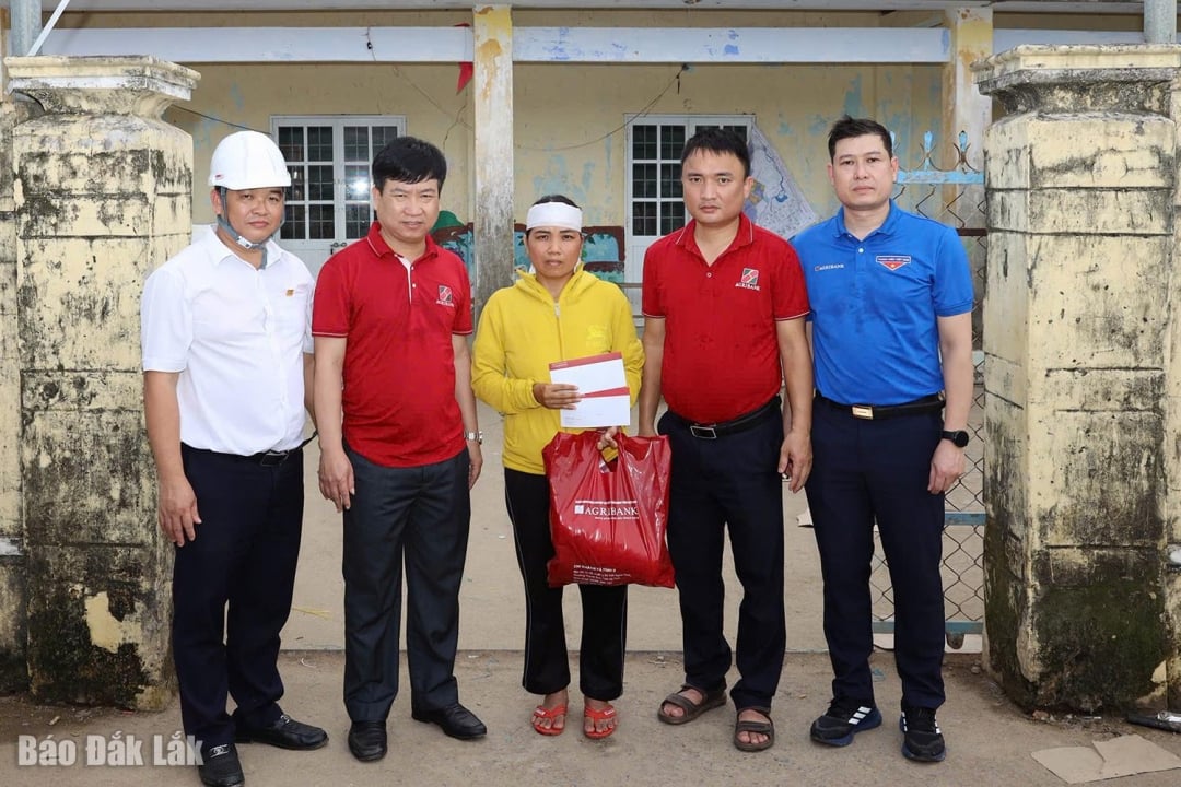 En representant från Agribank överlämnade gåvor för att stödja familjer vars släktingar dog på grund av översvämningar i Hoa Xuan kommun.