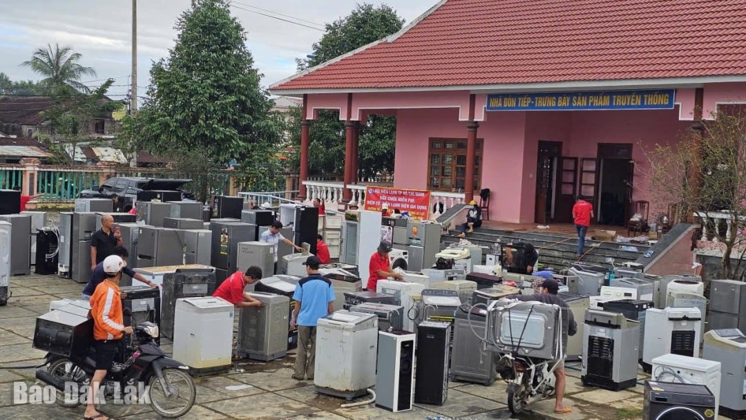 Penduduk komune Hoa Thinh membawa peralatan elektrik yang rosak selepas banjir ke pusat penerimaan untuk menerima sokongan pembaikan percuma.