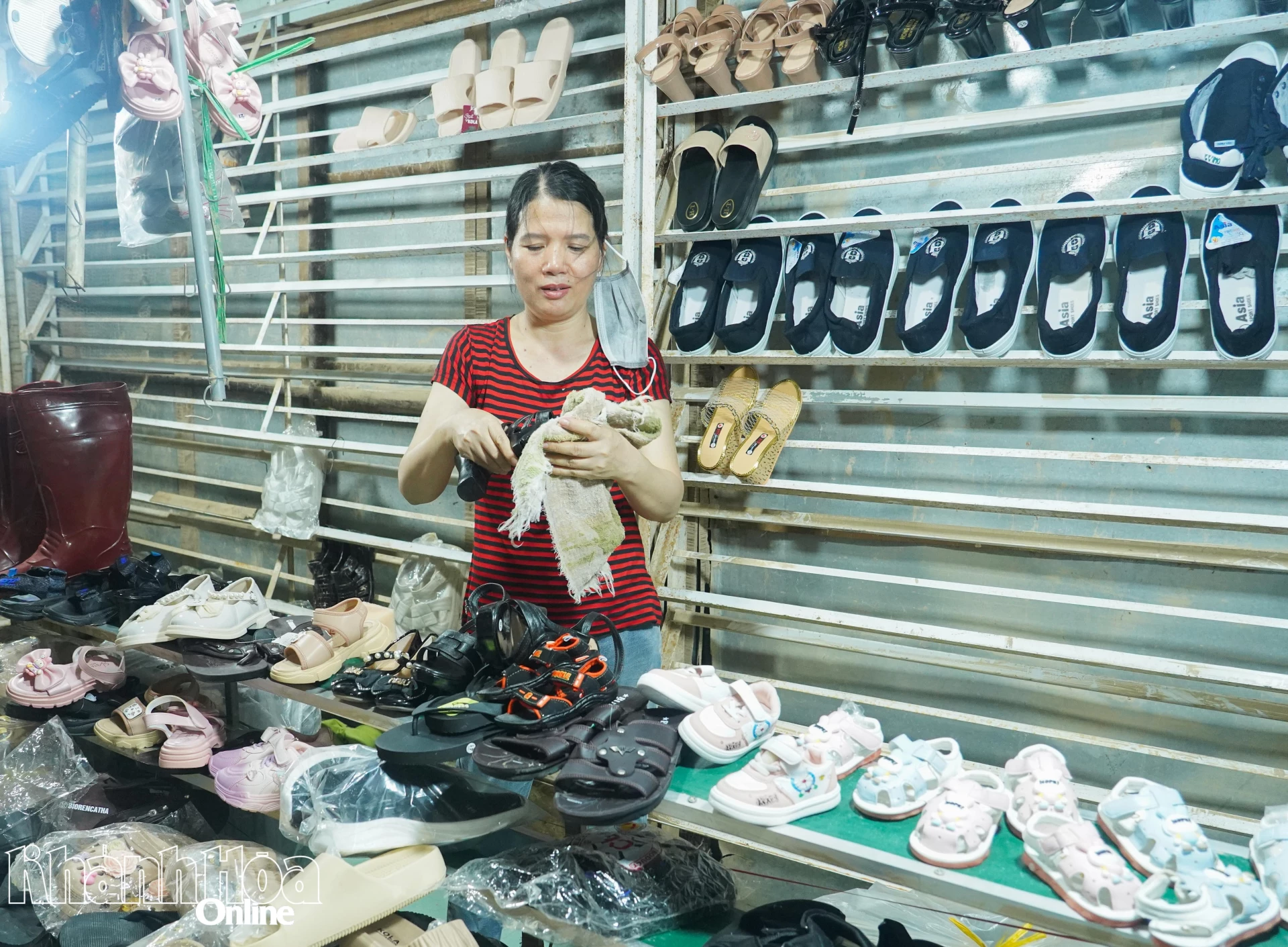 Prodejce na tržišti u vlakového nádraží Vinh Thanh uklízí své zboží po několika dnech záplav.
