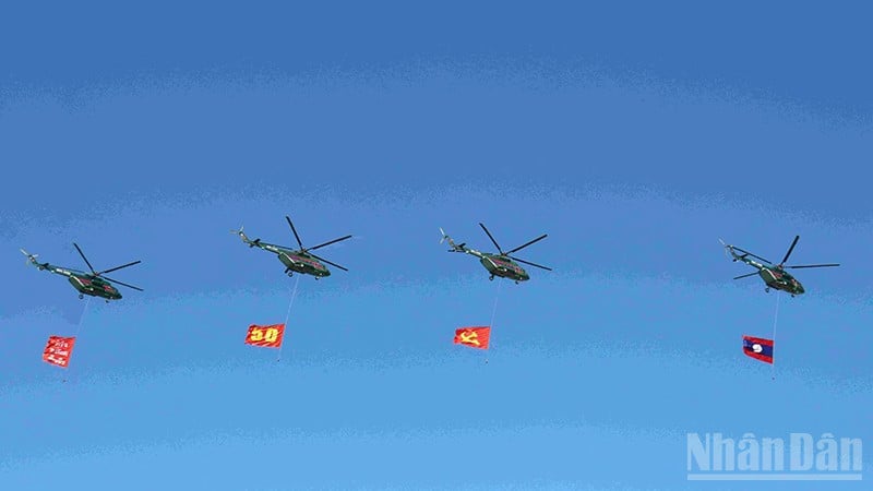 Đội hình máy bay trực thăng mang cờ Đảng, cờ Tổ quốc Lào trên bầu trời quảng trường That Luang. (Ảnh: DUY TOÀN)