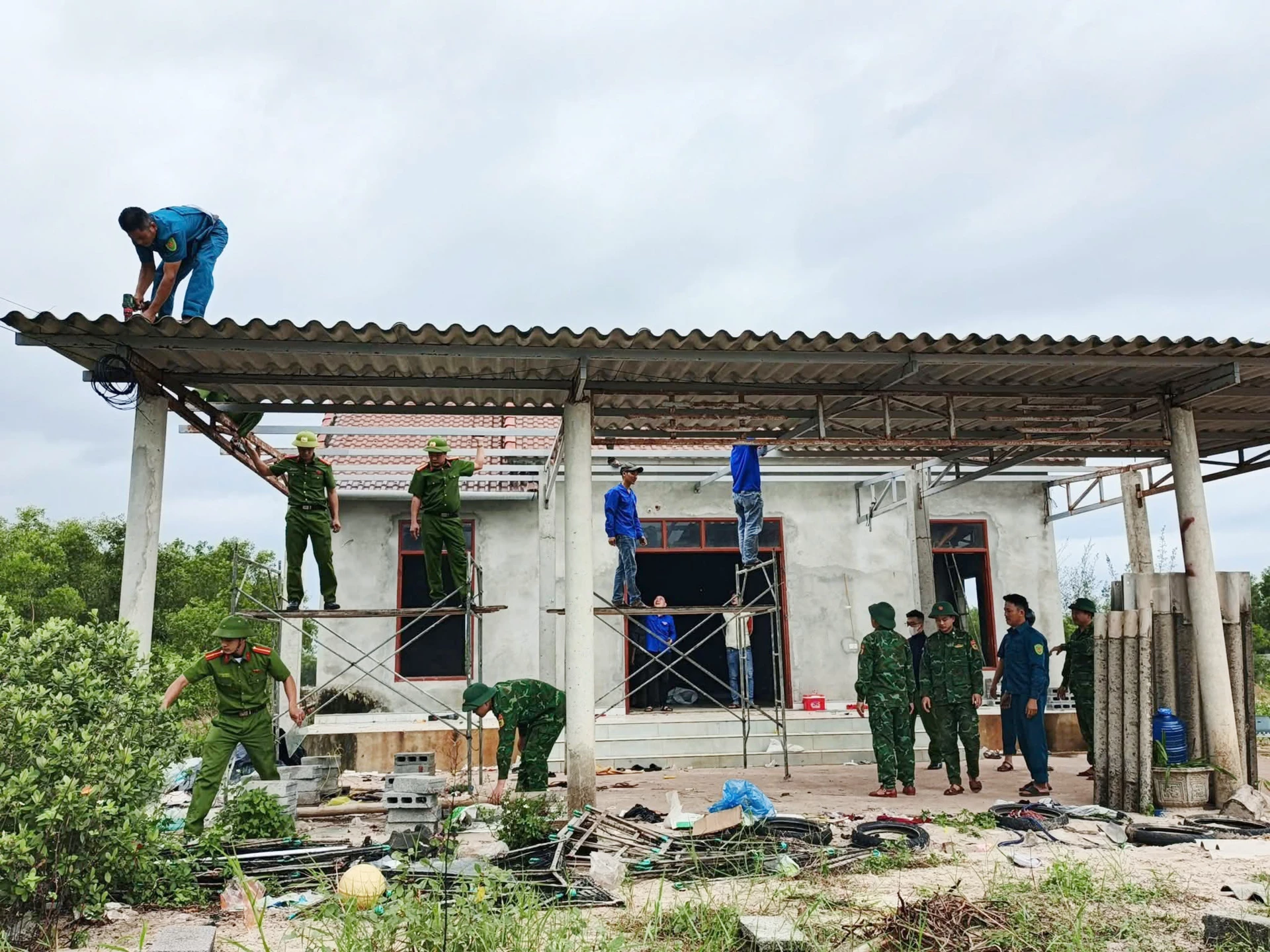 Các lực lượng chức năng ở xã Sen Ngư giúp dân tháo dỡ nhà cửa, công trình để bàn giao mặt bằng cho chủ đầu tư - Ảnh: B.T