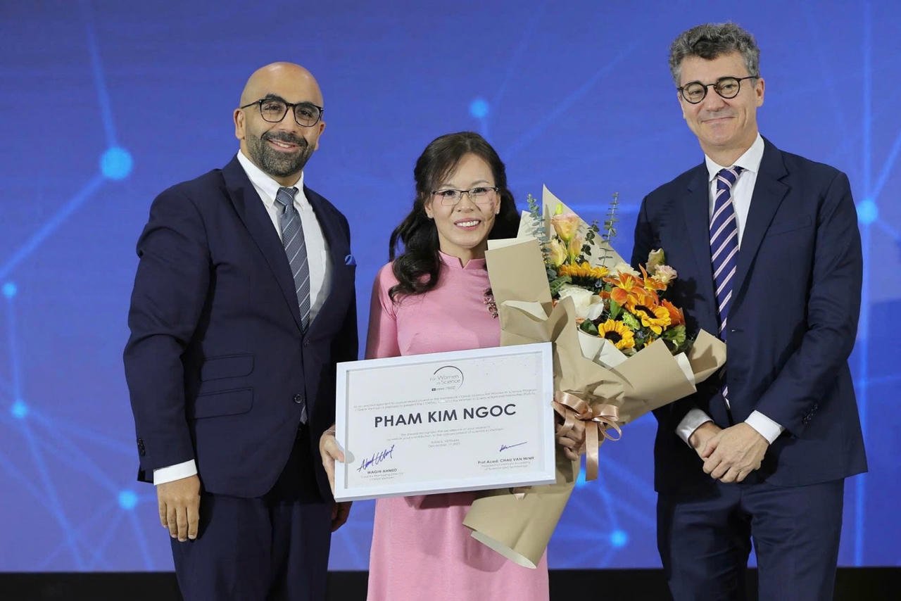 Г-н Вагих Ахмед, генеральный директор L'Oréal VietNam, и г-н Джонатан Уоллес Бейкер, главный представитель ЮНЕСКО во Вьетнаме, вручили сертификат о стипендии доценту, доктору Фам Ким Нгок.