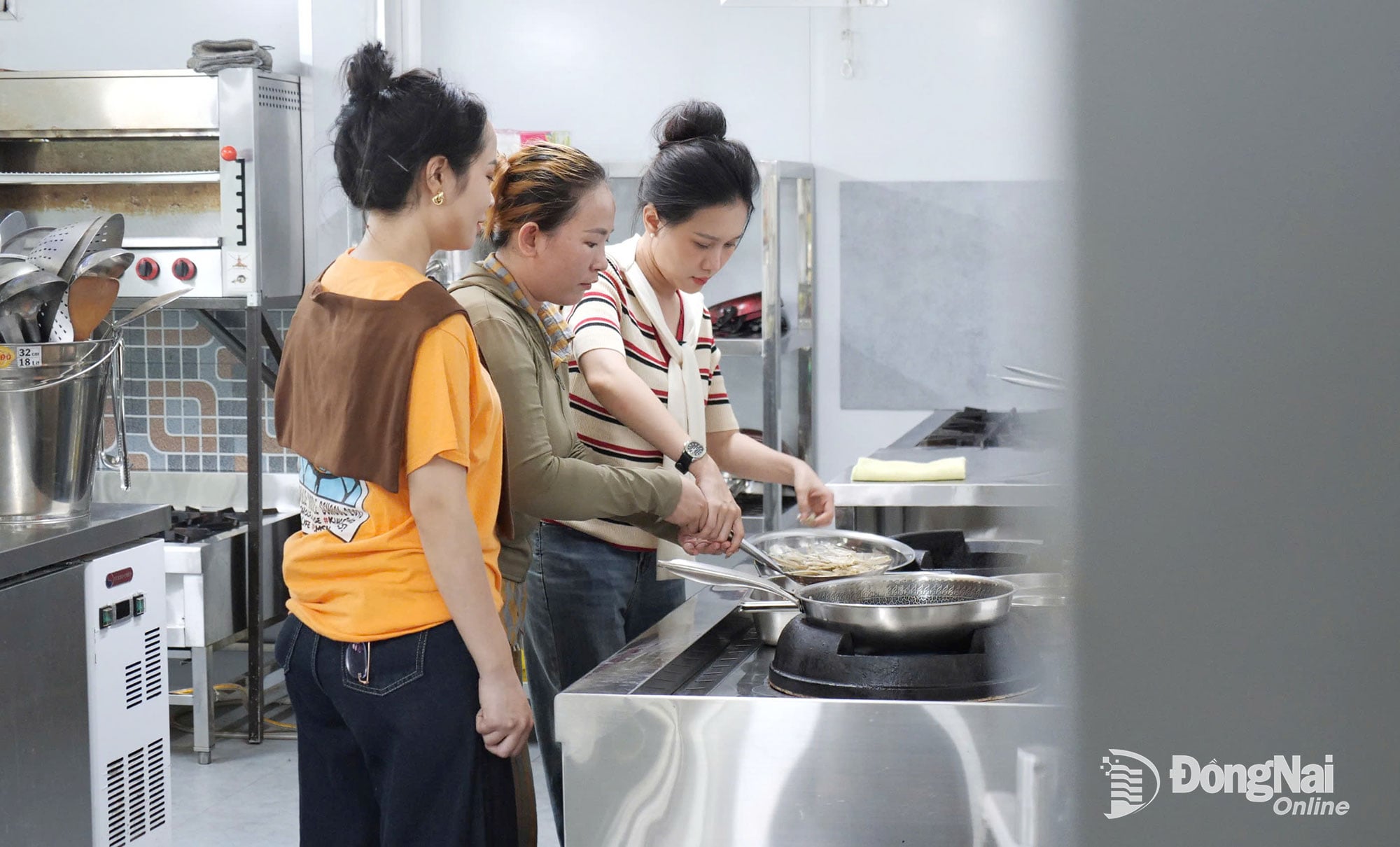 Ms. Tran Thi Thuy Duy, Head Chef of the Center for Ecology - Culture - History of the D War Zone, guides Minh Tuyet and Dieu Hien in preparing dried fish - a rustic specialty of the Tri An Lake area. Photo: Tien Dung 