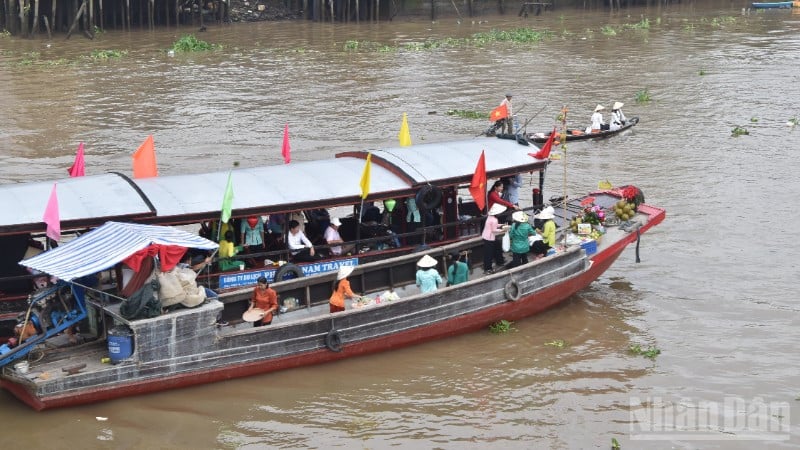 Gjenskaping av kjøps- og salgsscenen mellom handelsmenn og turister på Cai Be flytende marked om morgenen 4. desember 2025.