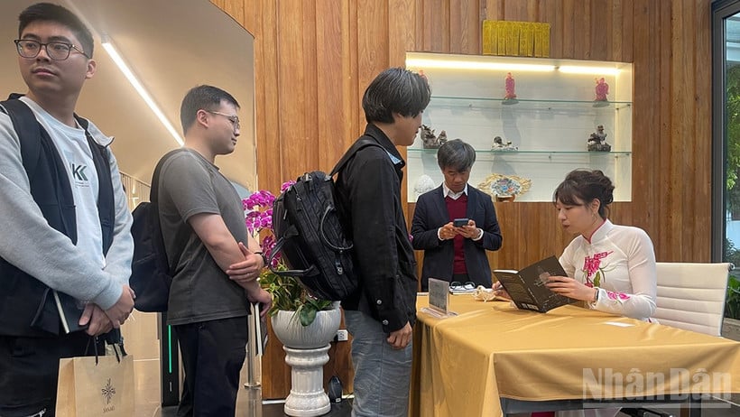 ری کودان در هانوی برای خوانندگان کتاب امضا میکند.