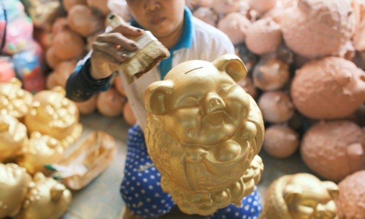 ساؤ دیو ورکشاپ میں ایک کاریگر ہاتھ سے بنے ہوئے لکڑی کے کلگوں کے جوڑے کو مکمل کر رہا ہے۔