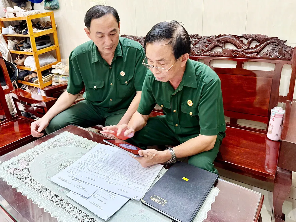 O Sr. Nguyen Ngoc Tham, veterano no cargo de Secretário da Célula do Partido na Ala 20, Ala Minh Phung (à direita), é proficiente na operação de softwares eletrônicos. Foto: CAM NUONG