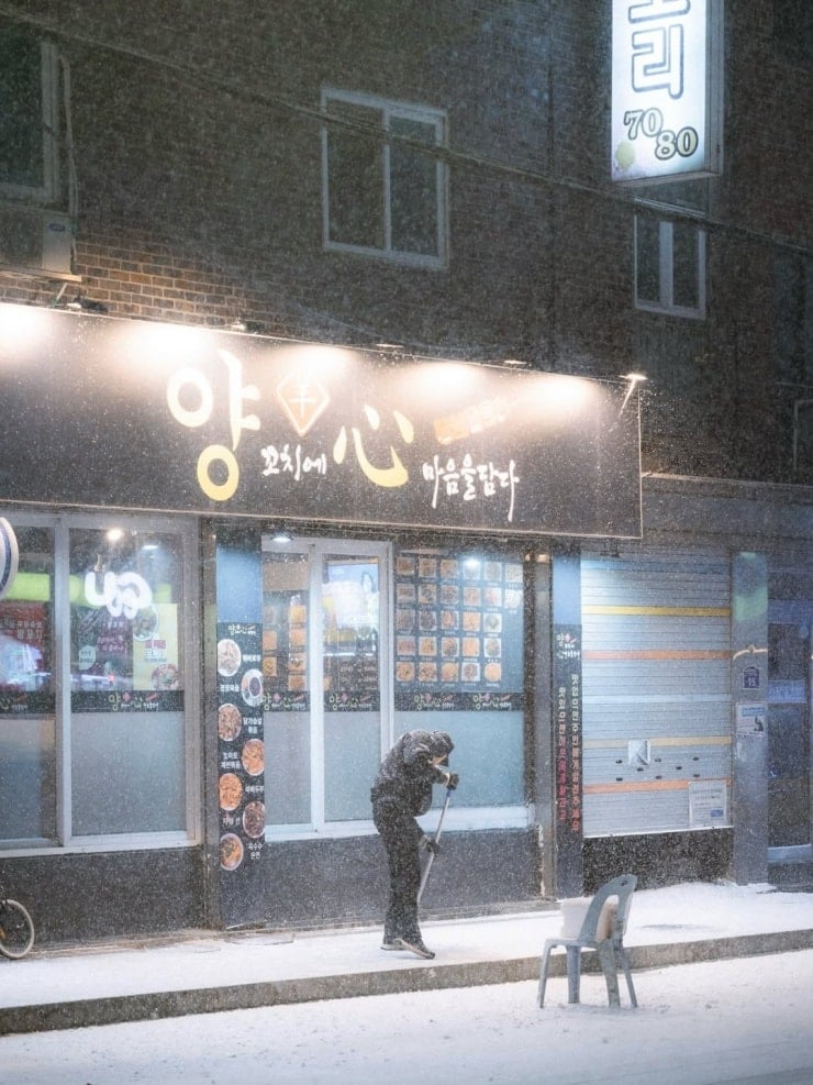 Hongik Üniversitesi yakınındaki sokakta küçük bir kardan adam yapılıyor.