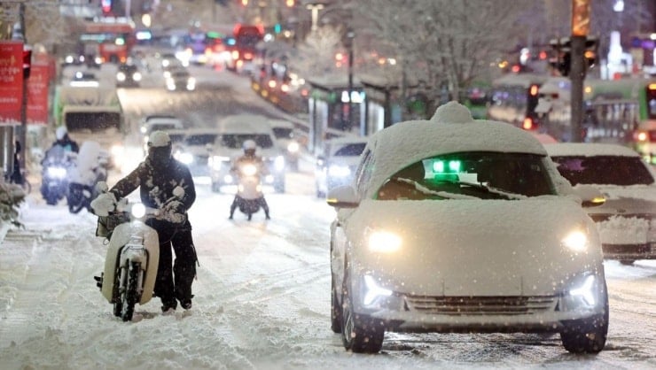 Gyeonggi Eyaletine bağlı Suwon'da 4 Aralık akşamı kar yağışı nedeniyle ana caddede araçlar yavaş ilerliyor.