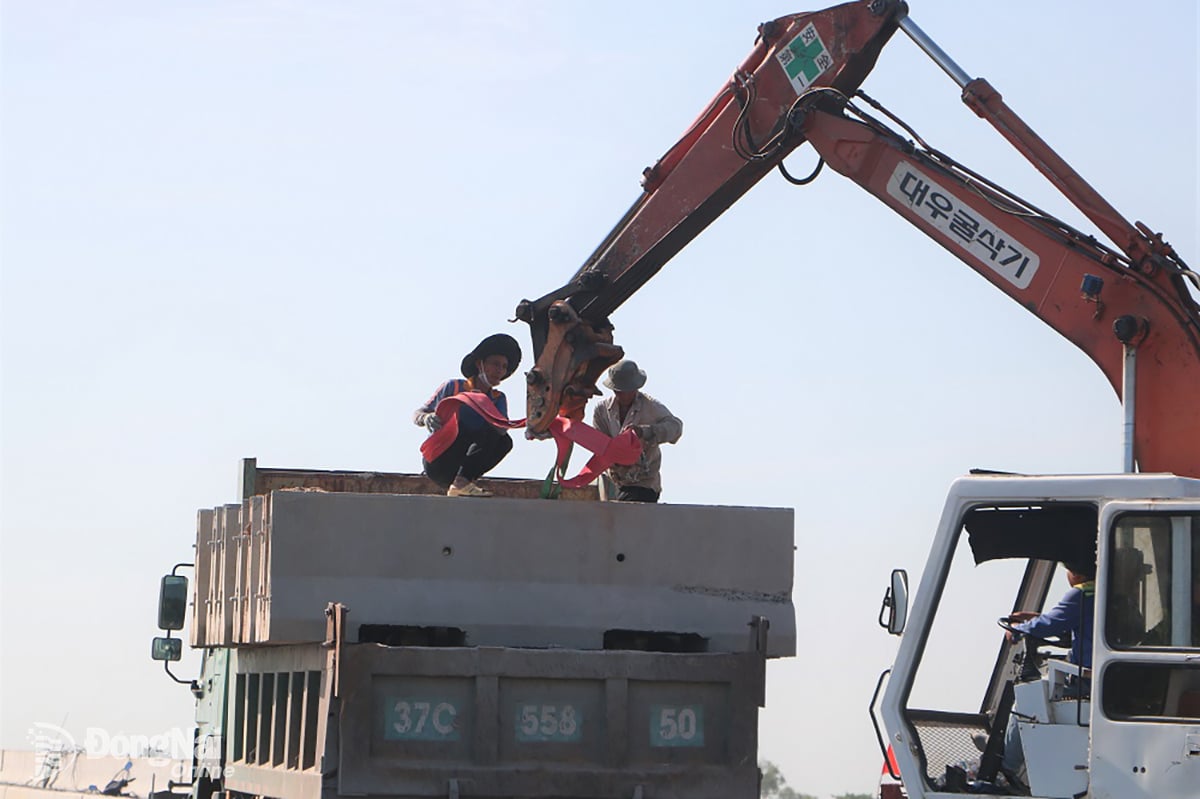 កម្មករ​ដំឡើង​ប្រព័ន្ធ​បន្ទះ​មធ្យម​នៅ​កំណាត់​ផ្លូវ​ក្រវ៉ាត់​ក្រុង​លេខ​៣ - ផ្លូវ​ល្បឿន​លឿន​ក្រុង​ហូជីមិញ​ឆ្លងកាត់​ខេត្ត។ រូបថត៖ Pham Tung