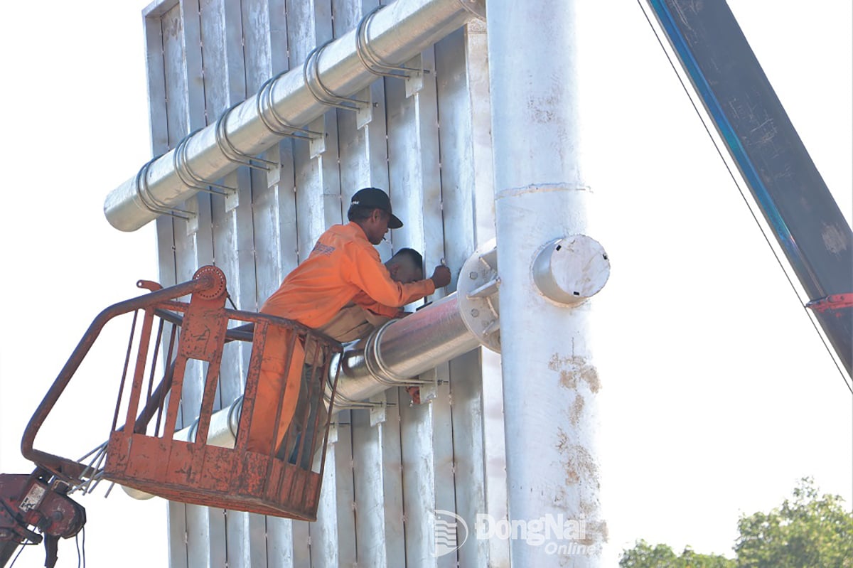 កម្មករ​ដំឡើង​ផ្លាក​សញ្ញា​ចរាចរណ៍​នៅ​ផ្លូវ​ក្រវ៉ាត់​ក្រុង​លេខ​៣ ផ្លូវ​ក្រវ៉ាត់​ក្រុង​ហូជីមិញ ឆ្លង​កាត់​ខេត្ត។ រូបថត៖ Pham Tung