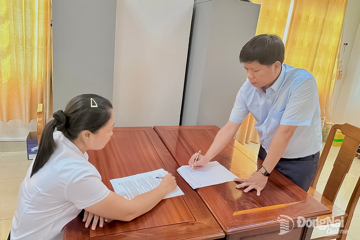 Lærer Nguyen Van Tai, en offentlig tjenestemann tilknyttet utdanningssektoren, Kultur- og samfunnsavdelingen i Folkekomiteen i Phu Nghia kommune, diskuterer arbeid med kolleger. Foto: CT.V