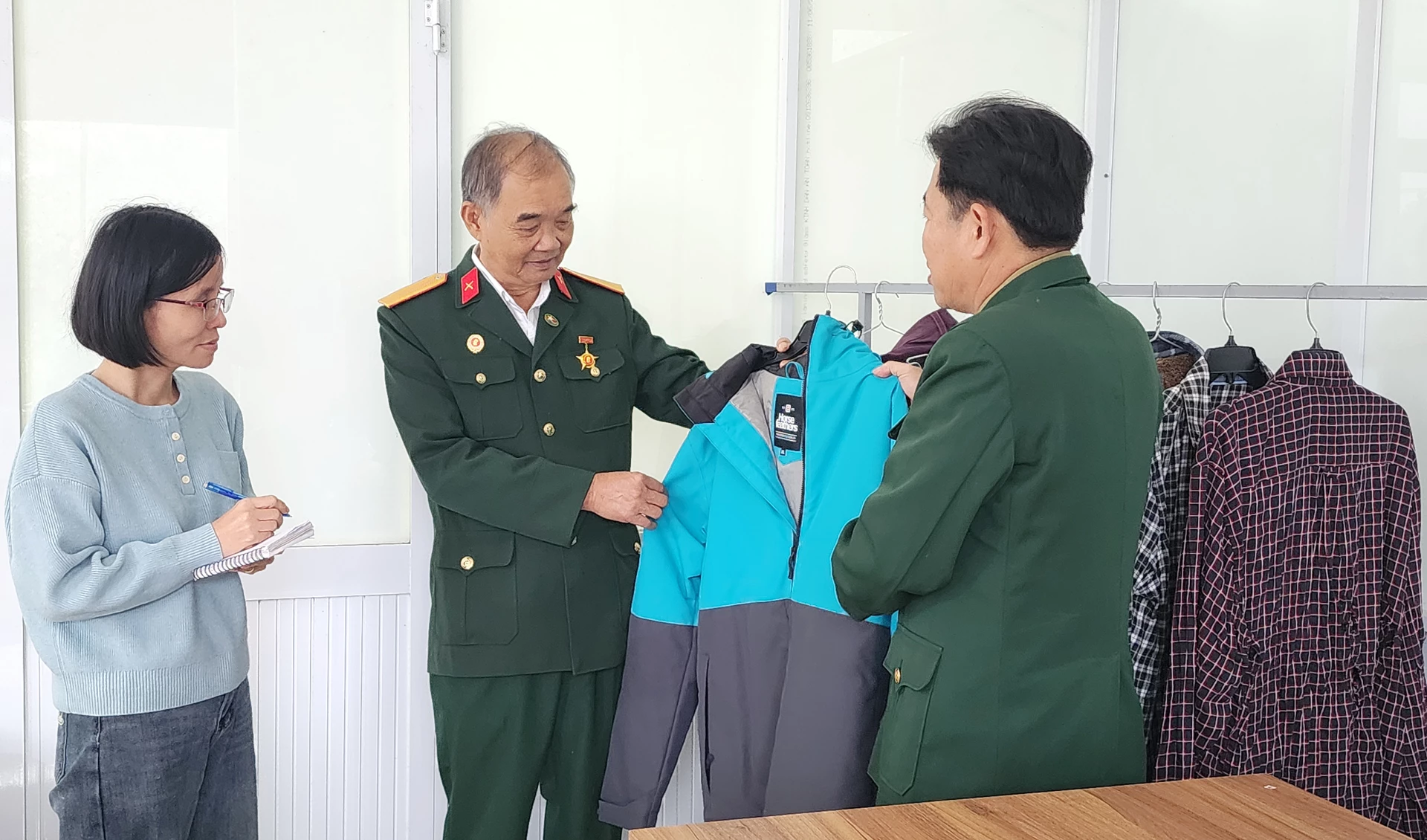 Ông Nguyễn Văn Cảnh và các sản phẩm may mặc của Công ty TNHH May xuất khẩu Cảnh Lộc - Ảnh: T.LONG