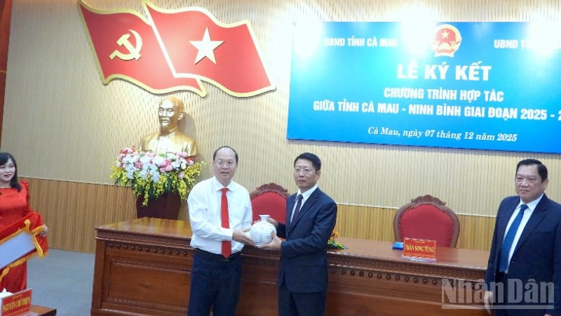 Nguyen Ho Hai, secretaris van het provinciaal partijcomité van Ca Mau (linkerpagina), overhandigt een souvenir aan een vertegenwoordiger van de provincie Ninh Binh tijdens de ondertekeningsceremonie.