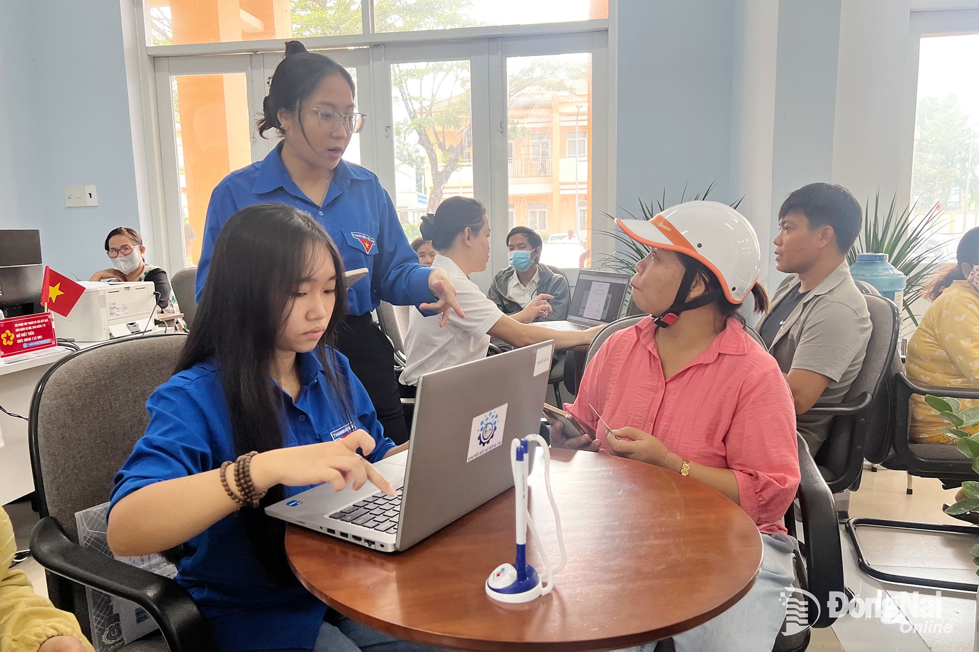 חברי איגוד הנוער ובני נוער מקדמים ותומכים באנשים לבצע הליכים אדמיניסטרטיביים באופן מקוון במרכז השירות למנהל הציבורי של קהילת שואן הואה. צילום: האי קוואן