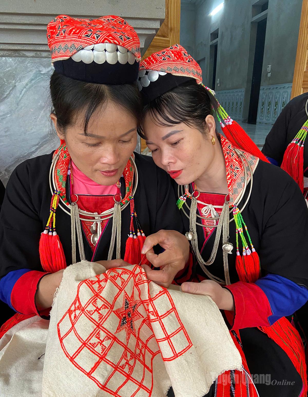 Klubbmedlemmarna vägleder varandra i att lära sig broderi.