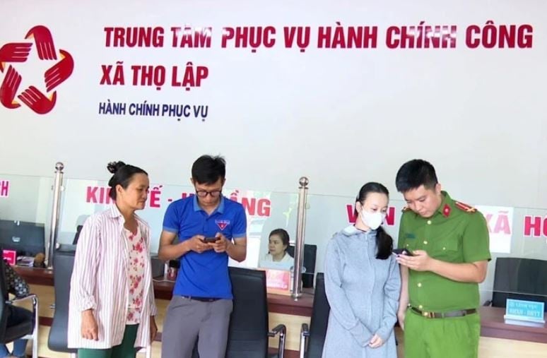Cán bộ, đoàn viên thanh niên xã Thọ Lập hỗ trợ, hướng dẫn người dân sử dụng các dịch vụ ứng dụng trên điện thoại thông minh khi đến làm việc tại Trung tâm Phục vụ hành chính công xã. Ảnh: Báo Thanh Hóa.