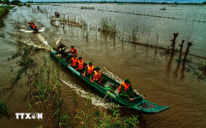 Offiserer og soldater ved Vinh Nguon grensevaktstasjon (An Giang provinsielle grensevaktkommando) koordinerer med andre styrker for å patruljere og kontrollere grensen under flomsesongen. (Foto: Cong Mao/VNA)
