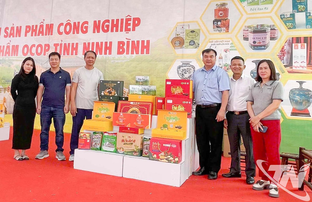 Equipe de trabalho no estande apresentando produtos industriais rurais típicos de Thai Nguyen na Feira.