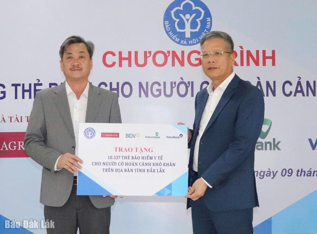 Biträdande chef för Vietnams socialförsäkring, Tran Dinh Lieu (höger), överlämnade en symbolisk plakett för att donera 10 337 sjukförsäkringskort till den provinsiella folkkommittén.
