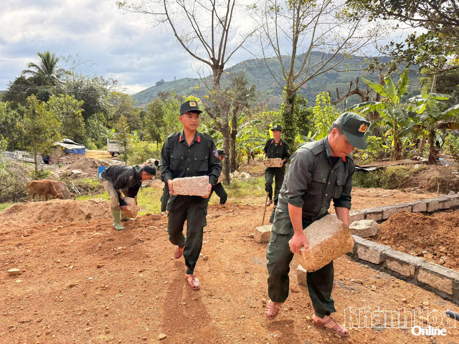 Мобильные полицейские и солдаты везут колотые камни на строительную площадку семьи г-жи Као Тхи Та Хиен для строительства дома.