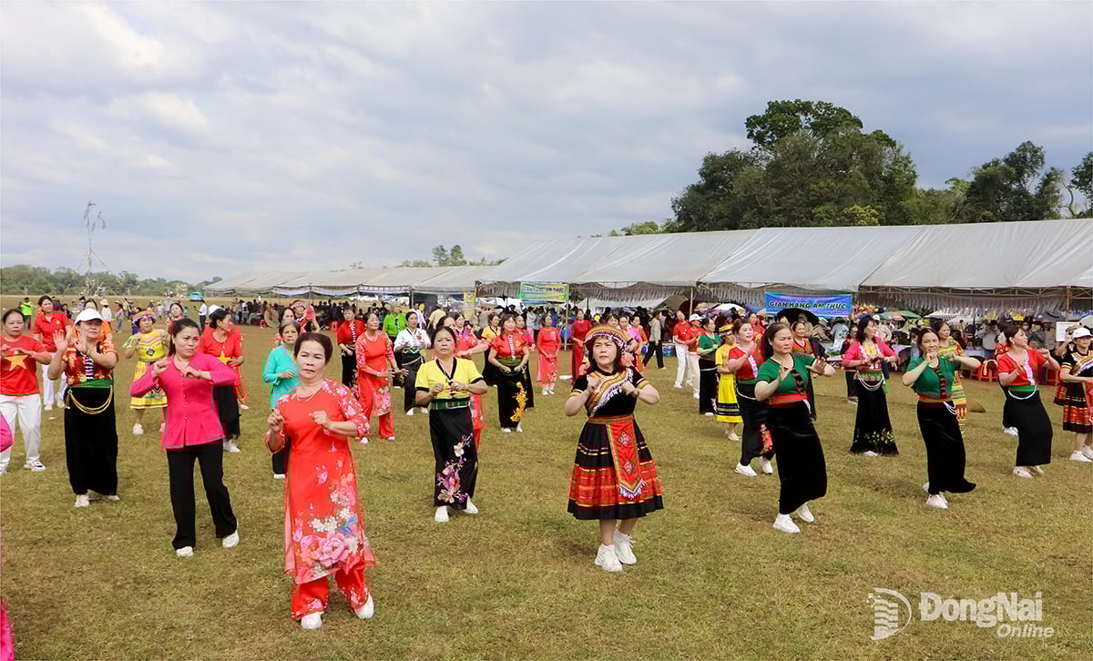 אנשים מקהילת טו סון מבצעים ריקודי עם באדמות העשב בו לאך בקהילת טו סון, אחד הנופים היפים המושכים תיירים.