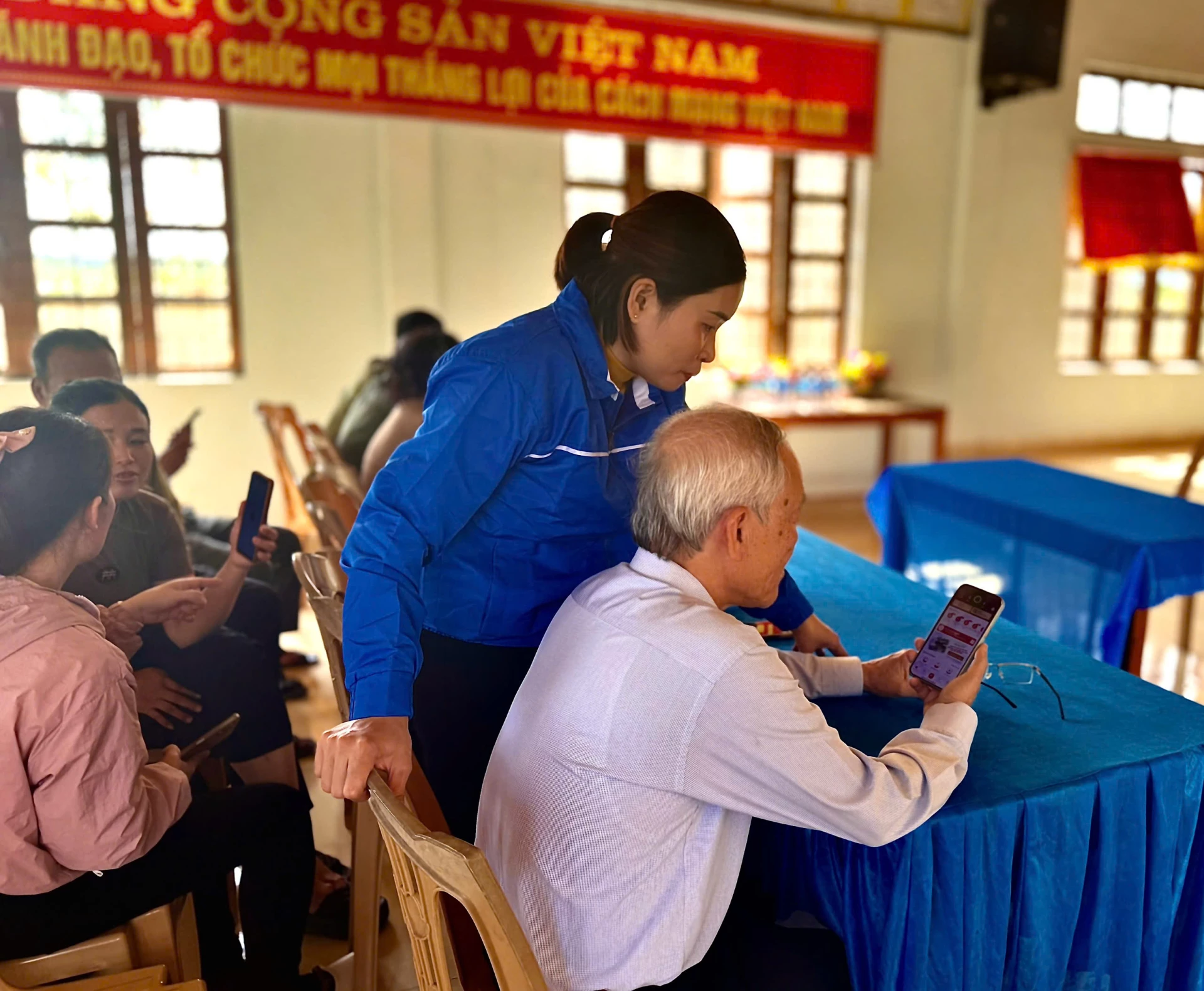 Члены команды по цифровым технологиям сообщества и проекта № 06 деревни Ха Тьен помогают жителям интегрировать карты медицинского страхования и электронные медицинские карты в приложение VNeID. Фото: Х.Н.