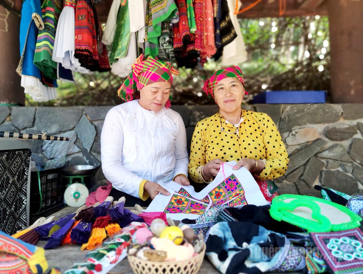 นางสาวเจียง ถิ มา (ซ้าย) และนางสาวมา ถิ เลียน ที่บูธแนะนำผลิตภัณฑ์ผ้าไหมม้ง