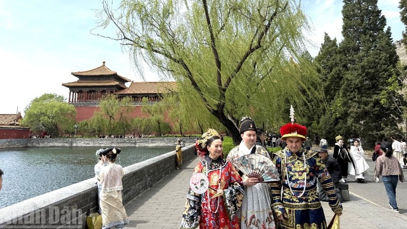 Иностранные туристы позируют для фотографий в традиционных костюмах в Запретном городе в Пекине, Китай. (Фото: Хуу Хун)