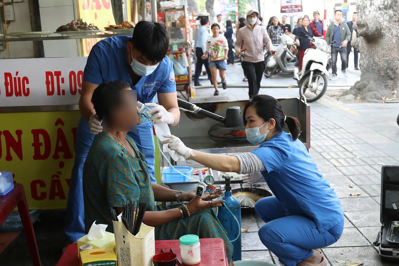 Seorang wanita menerima rawatan perubatan daripada pekerja penjagaan kesihatan. (Foto: Vietnamnet).