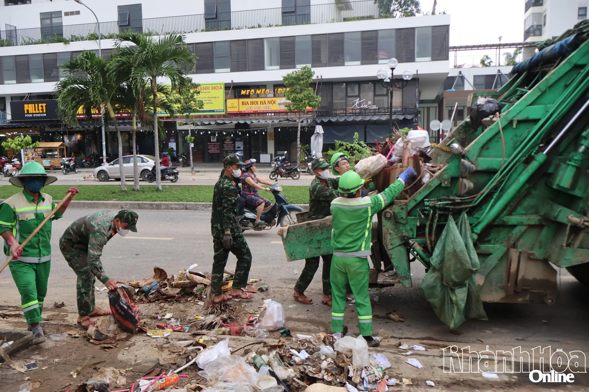 Arbeidere og soldater samler opp rusk og avfall etter flom i Tay Nha Trang-distriktet.