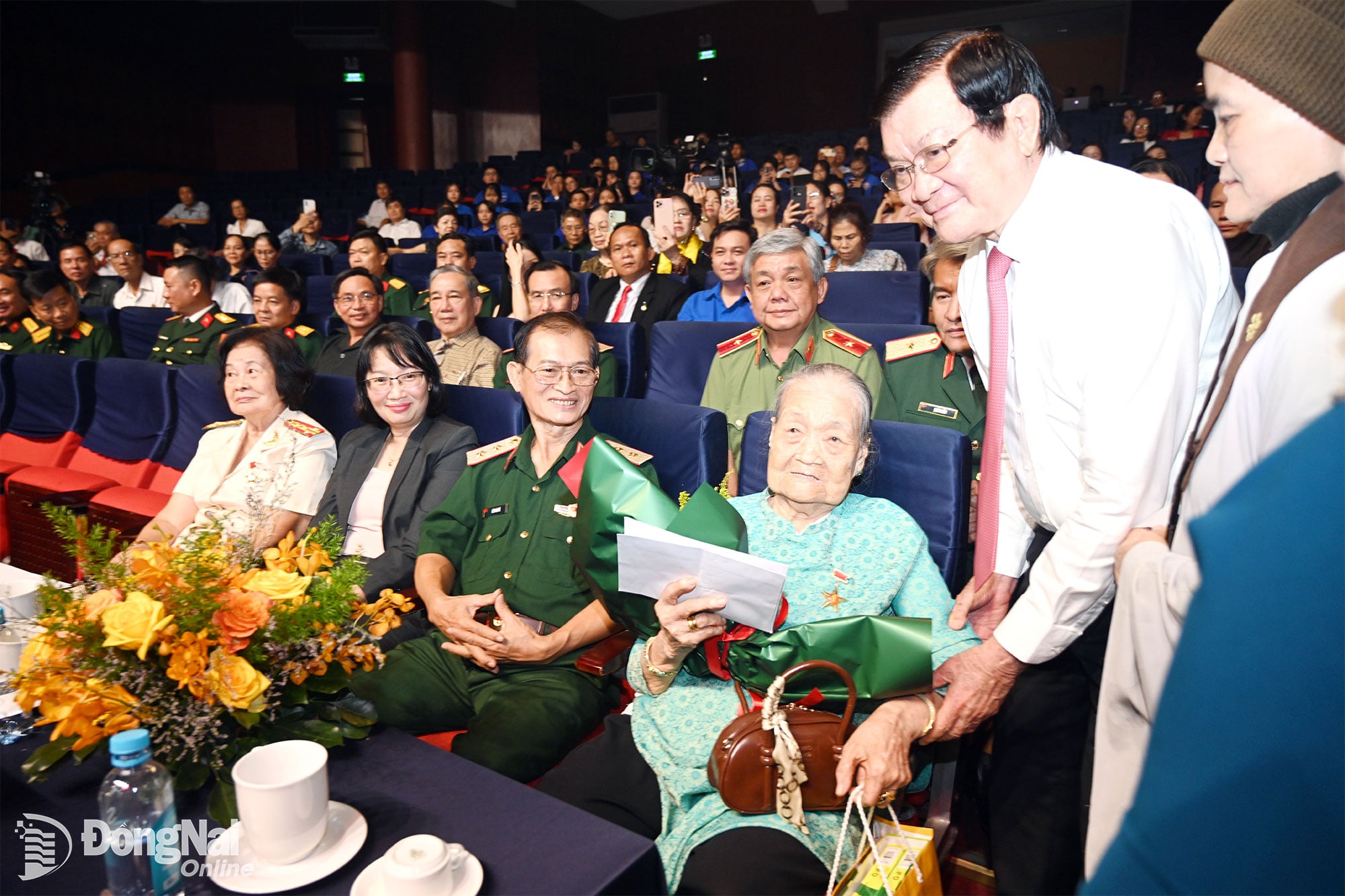 Förre presidenten Truong Tan Sang och organisationskommittén överlämnade blommor och gåvor för att uttrycka sin tacksamhet till den vietnamesiska hjältemodern Nguyen Thi Ai. Foto: Phuoc Tho.