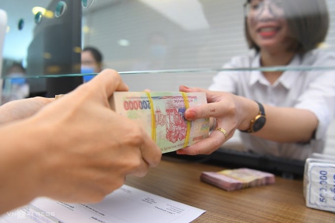 Customers conducting transactions at a private bank. Photo: Giang Huy
