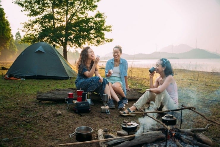 En grupp turister vilar och äter picknicklunch under sin vandringstur.