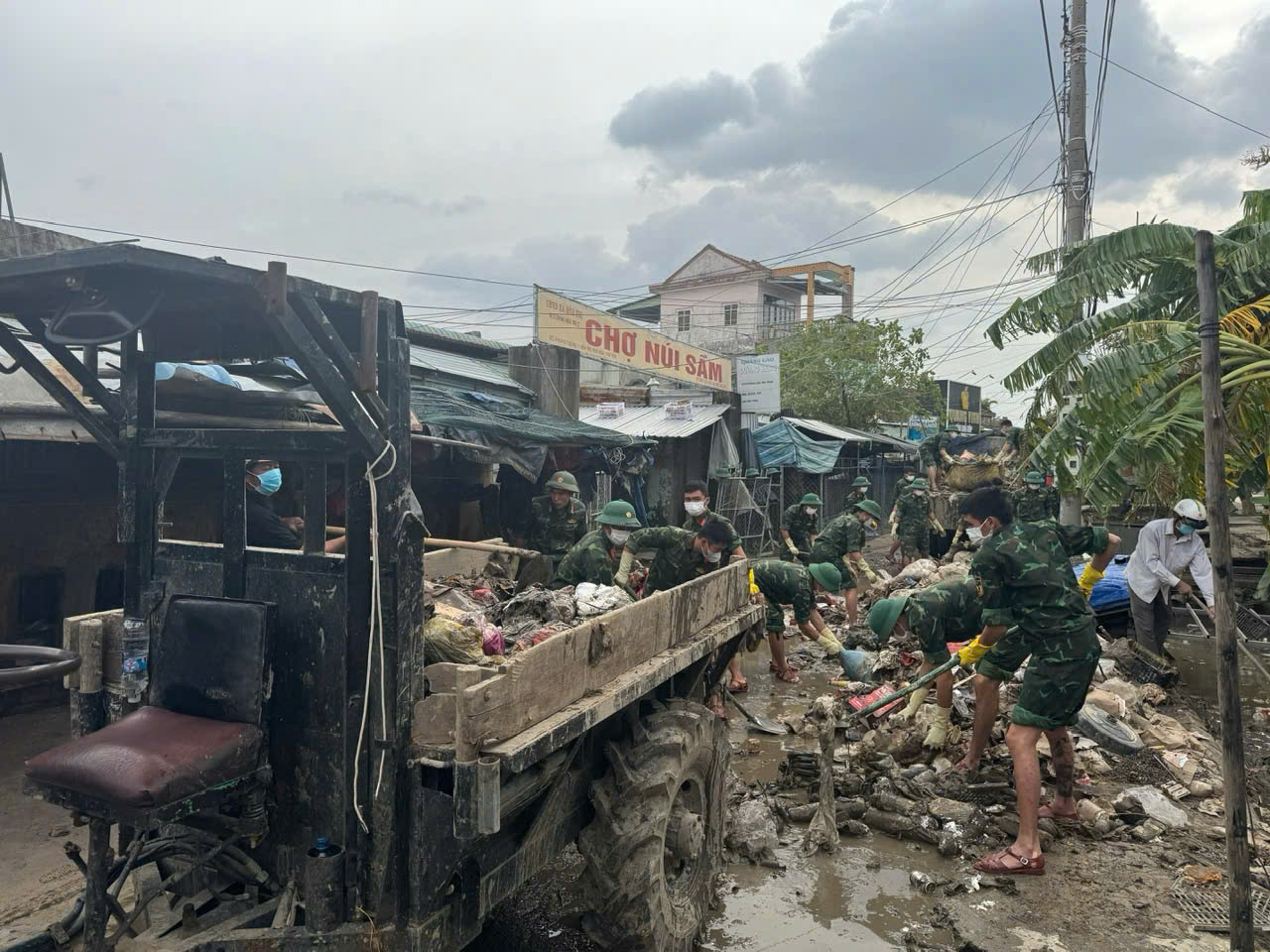 Ofițerii și soldații Brigăzii 198 Forțe Speciale curăță noroiul și molozul și se ocupă de consecințele inundațiilor de la piața Nui Sam.