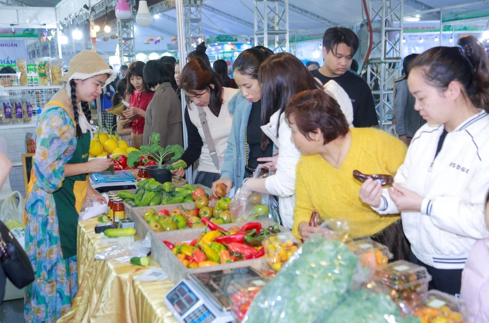 បរិយាកាសទិញទំនិញដ៏មមាញឹកនៅតំបន់តាំងពិព័រណ៍ដែលបង្ហាញផលិតផលកសិកម្ម និងអាហារដែលមានសុវត្ថិភាពពីខេត្តថាញ់ហ័រ ឆ្នាំ២០២៥។