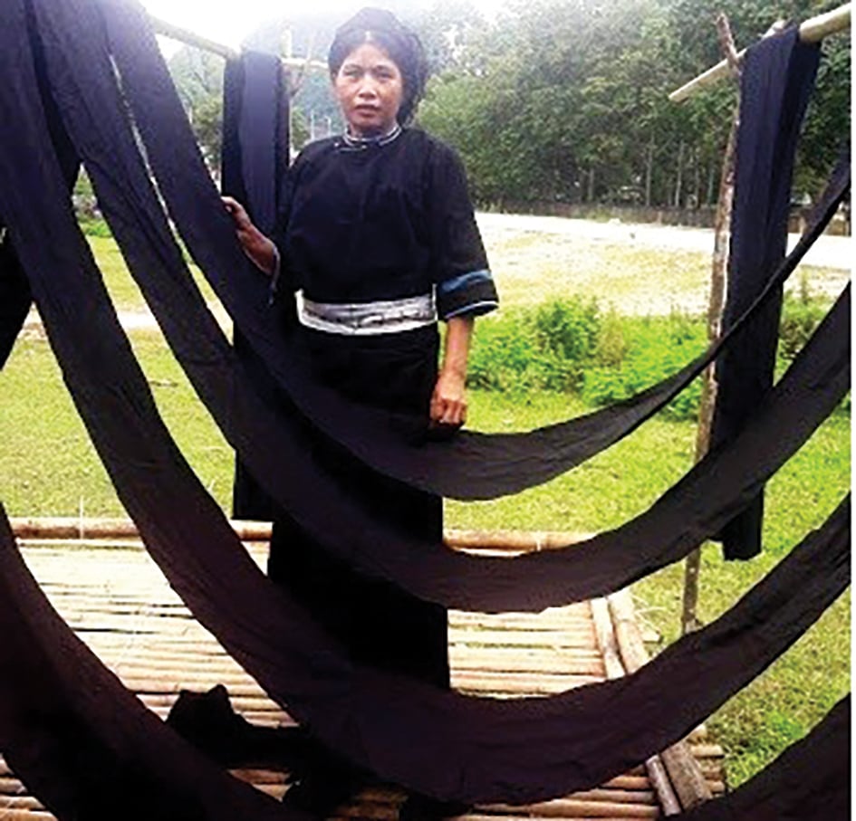 Nung An-håndverkere farger og tørr indigo-stoff i landsbyen Phja Chang, Quang Uyen kommune.