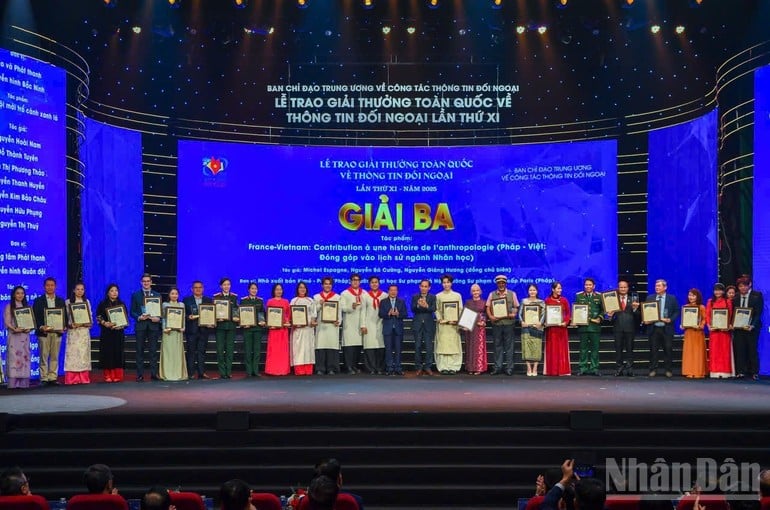 Tovarășul Le Hoai Trung, secretarul Comitetului Central al Partidului și ministru al Afacerilor Externe, și tovarășul Lai Xuan Mon, membru al Comitetului Central al Partidului și șef adjunct al Comitetului Permanent al Departamentului Central de Propagandă și Mobilizare a Maselor, au înmânat autorilor premiul al treilea. (Foto: Trong Hai)