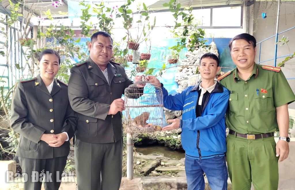 Ο κ. Le Van Dinh (δεύτερος από δεξιά) παραδίδει τον σπάνιο αργό Λόρι στις αρχές για να τον αφήσουν πίσω στην άγρια φύση.