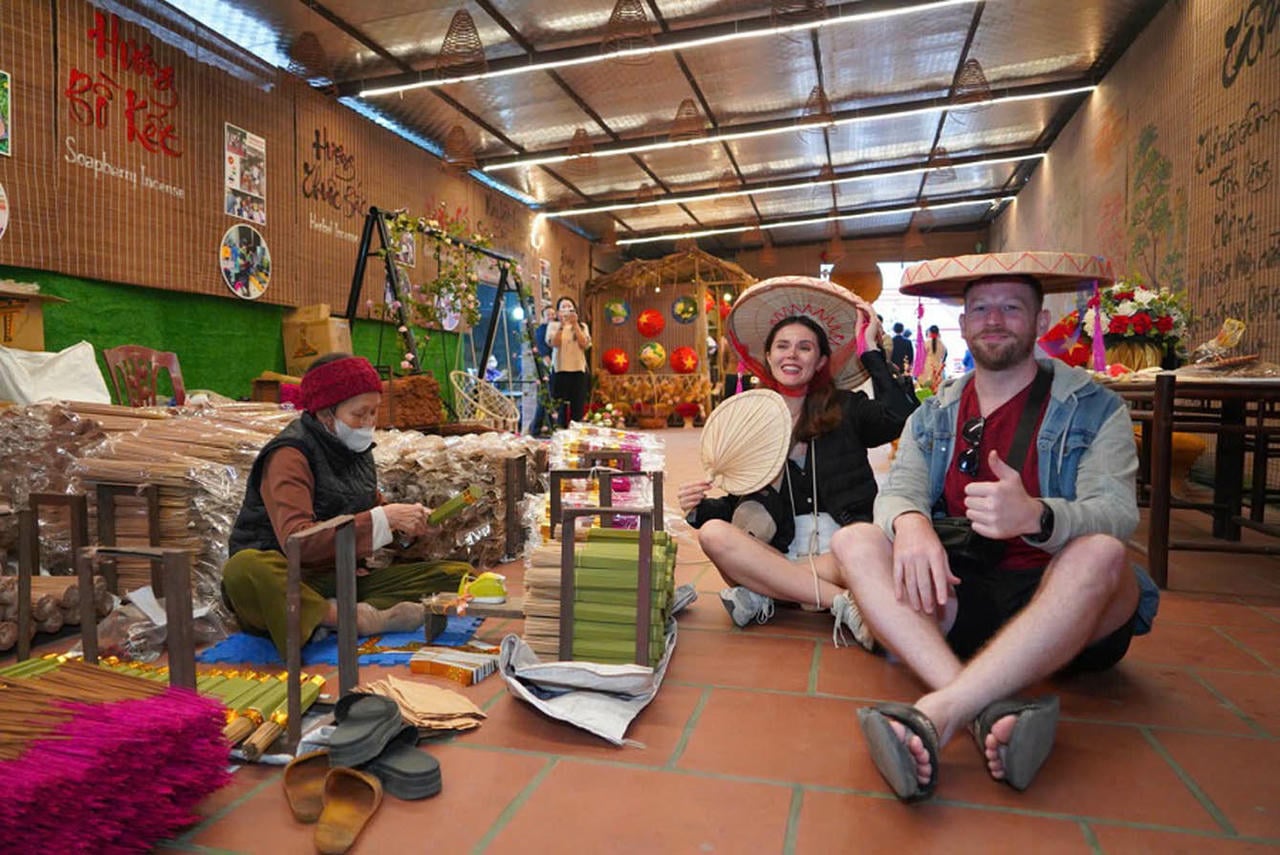 Internasjonale turister nyter opplevelsen i håndverkslandsbyen. (Foto: Linh Tam)