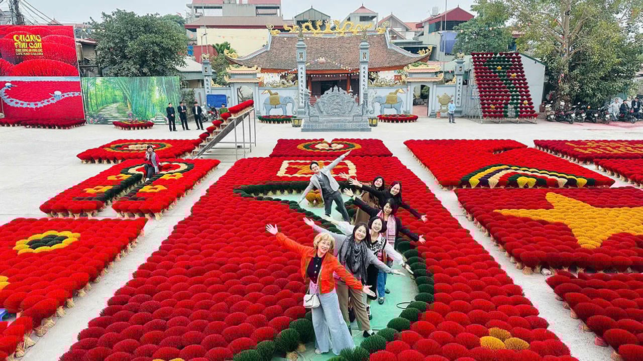 Turister sjekker inn ved utstillingen av røkelsespinner i Quang Phu Cau. (Foto: Linh Tam)